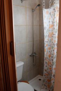 a bathroom with a toilet and a shower curtain at Alojamiento Ecológico Kurache in Tandil +70 photos