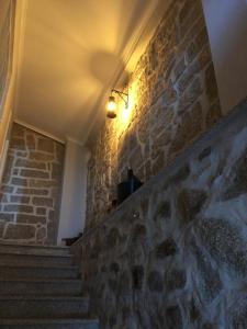 een stenen trap met een licht op de muur bij Casa das Bonecas in Mangualde