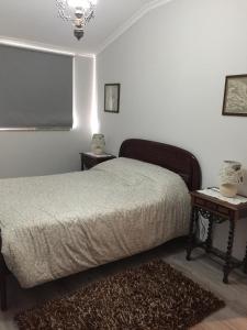 a bedroom with a bed and two tables and a window at Casa das Bonecas in Mangualde