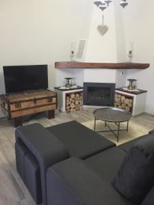 sala de estar con sofá y chimenea en Casa das Bonecas, en Mangualde