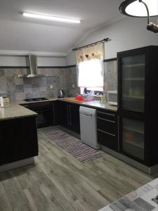 a kitchen with black cabinets and a white dishwasher at Casa das Bonecas in Mangualde