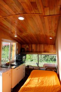 a room with a kitchen and a bed in a rv at Alojamiento Ecológico Kurache in Tandil
