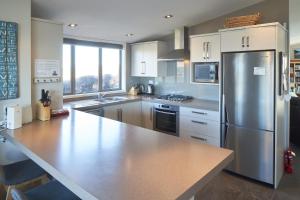 a large kitchen with a stainless steel refrigerator at Hillcrest Lodge A - Lake Tekapo in Lake Tekapo