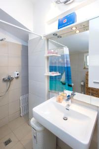 een badkamer met een wastafel en een spiegel bij Apartment Seaside, free parking in Šibenik