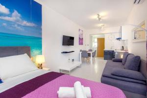 ein Schlafzimmer mit einem Bett und einem Sofa sowie eine Küche in der Unterkunft Apartment Seaside, free parking in Šibenik