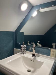 uma casa de banho com um lavatório branco e um espelho. em Jackson House Inn em Woodstock