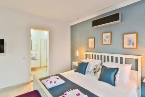 a bedroom with a large white bed with blue pillows at Villa Fiore in Kalkan