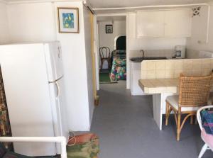 a kitchen with a refrigerator and a table in a kitchen at Rest Haven Beach Cottages in Saint Joseph