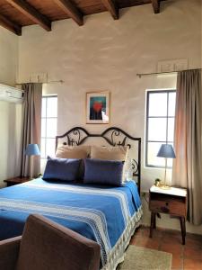 a bedroom with a bed with a blue comforter at Casa Magdalena in San Carlos