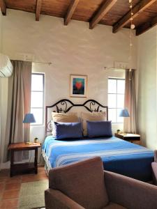 a bedroom with a blue bed and a couch at Casa Magdalena in San Carlos