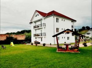 a large white house with a large yard with green grass at Pensiunea Casa Albă in Beclean