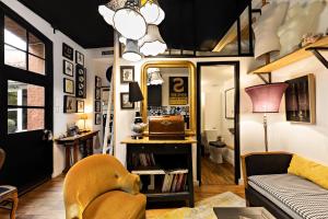 un soggiorno con divano e specchio di Les Petites Suites Dieppoises - L'Atelier Couture a Dieppe