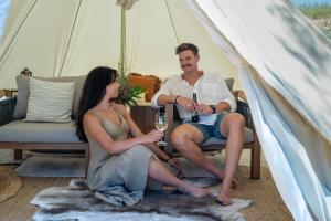 a man and woman sitting in a tent with wine glasses at KI Seafront Holiday Park in Penneshaw