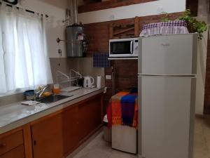 a kitchen with a white refrigerator and a sink at Quinta El Descanso in Puerto Madryn +14 photos