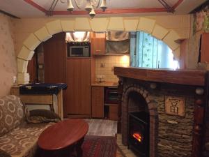 eine Küche mit einem Wohnzimmer mit einem Kamin in der Unterkunft Мини-Квартира SMART Карпенка 20 WI-FI центр/парк 5мин in Ternopil