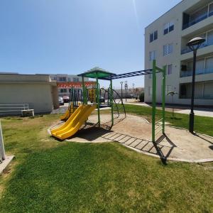 a playground with a yellow slide in a park at DEPARTAMENTO EL OASIS in La Serena
