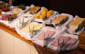 a table with different types of cheese and other foods at Caxias Thermas Hotel in Piratuba