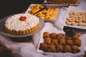 a table topped with trays of different types of pastries at Caxias Thermas Hotel in Piratuba