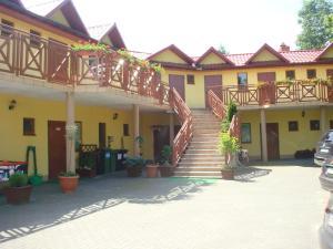 a large yellow building with stairs and a balcony at Willa Słoneczna in Okuninka