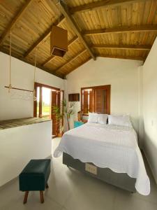 una camera da letto con un letto grande con soffitto in legno di Pousada Refúgio Náutico a Passo de Torres