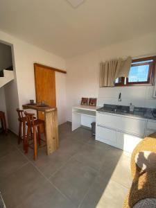una cucina con un bancone, un tavolo e delle sedie di Pousada Refúgio Náutico a Passo de Torres