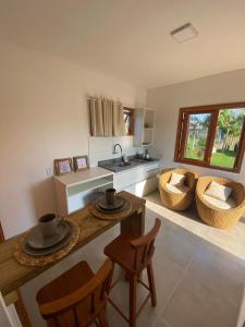 una cucina con tavolo, sedie e lavandino di Pousada Refúgio Náutico a Passo de Torres