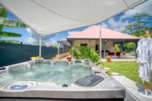 a hot tub in the backyard of a house at Villa Mabèlo enracinée dans la mémoire ouverte sur le monde in Gros-Morne