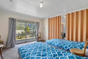 a hotel room with two beds and a balcony at Millard House - Marlborough Sounds in Grove