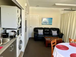 a living room with a couch and a table at Jennie's In Whitianga in Whitianga