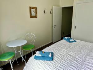 a bedroom with a bed and a table and chairs at Jennie's In Whitianga in Whitianga