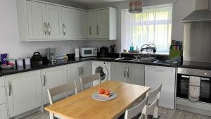 a kitchen with a table with a plate of fruit on it at Beautiful cottage in a wonderful Highland setting in Drumbeg