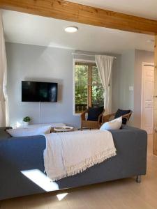 ein Schlafzimmer mit einem großen Bett und einem Sofa in der Unterkunft Chalet «L'Autrichien» de Charlevoix in Petite-Rivière-Saint-François