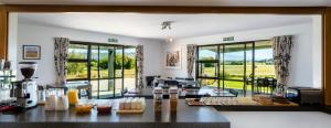 una habitación con una mesa con comida y ventanas en Inverlair Lodge, en Oturehua