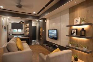 - un salon avec un canapé et une télévision dans l'établissement Designer Suite Apartment Seaview 10pax Families Suite, à Kuah