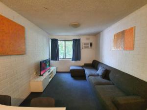 a living room filled with furniture and a window at Perth City Apartment Hotel in Perth