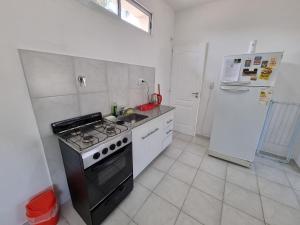 a kitchen with a stove and a refrigerator at Monoambiente en el centro de la Ciudad. in Mercedes