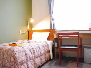 Ένα ή περισσότερα κρεβάτια σε δωμάτιο στο Station Business Hotel Tenshukaku