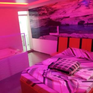 a bedroom with a bed with pink lights on it at Hotel Gold Park in Franco da Rocha