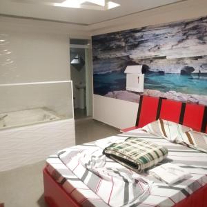 a bedroom with a bed with a painting on the wall at Hotel Gold Park in Franco da Rocha