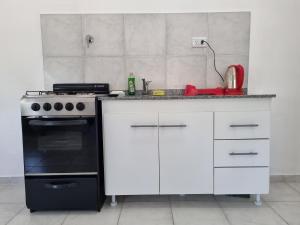 a kitchen with a stove and a white counter top at Monoambiente en el centro de la Ciudad. in Mercedes