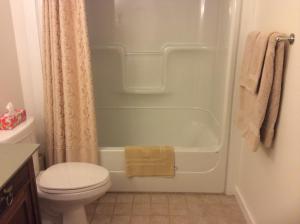 a bathroom with a tub and a toilet and a shower at The Water's Edge Inn & Gallery in Baddeck