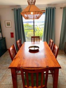 una sala da pranzo con tavolo e sedie in legno di Wintersun Holiday Cottages a Emu Bay