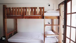 two bunk beds in a room with a window at BAAN64 Hostel in Hat Yai