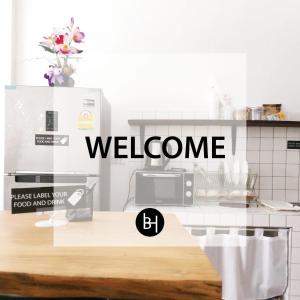 - un panneau de bienvenue sur un comptoir dans une cuisine dans l'établissement BAAN64 Hostel, à Hat Yai
