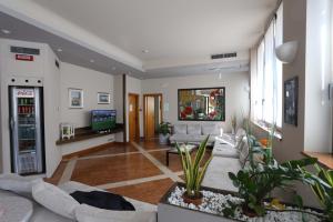 sala de estar con muebles blancos y TV en Hotel Roma, en Bussolengo