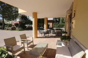 un patio con sillas, mesa y mesas en Hotel Roma, en Bussolengo