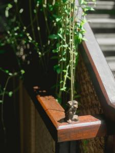 a small elephant figurine sitting on a wooden bench at ARTOTEL Haniman Ubud in Ubud
