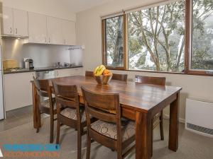 a kitchen with a wooden table with a bowl of bananas on it at Golden Eagle 1 in Thredbo