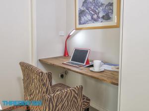 a room with a desk with a laptop and a chair at Golden Eagle 1 in Thredbo
