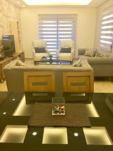 a living room with a couch and a table at Elite Residence - Furnished Apartments in An Nakhlah